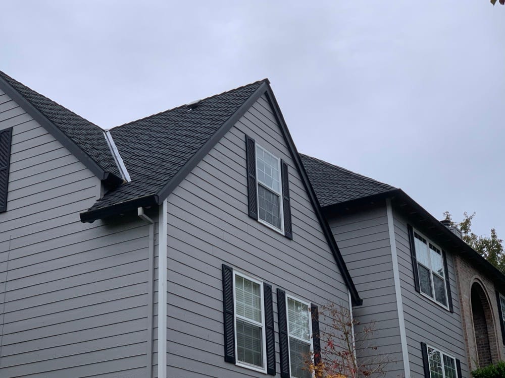 Gable and valley detail on a gray home with a new roof