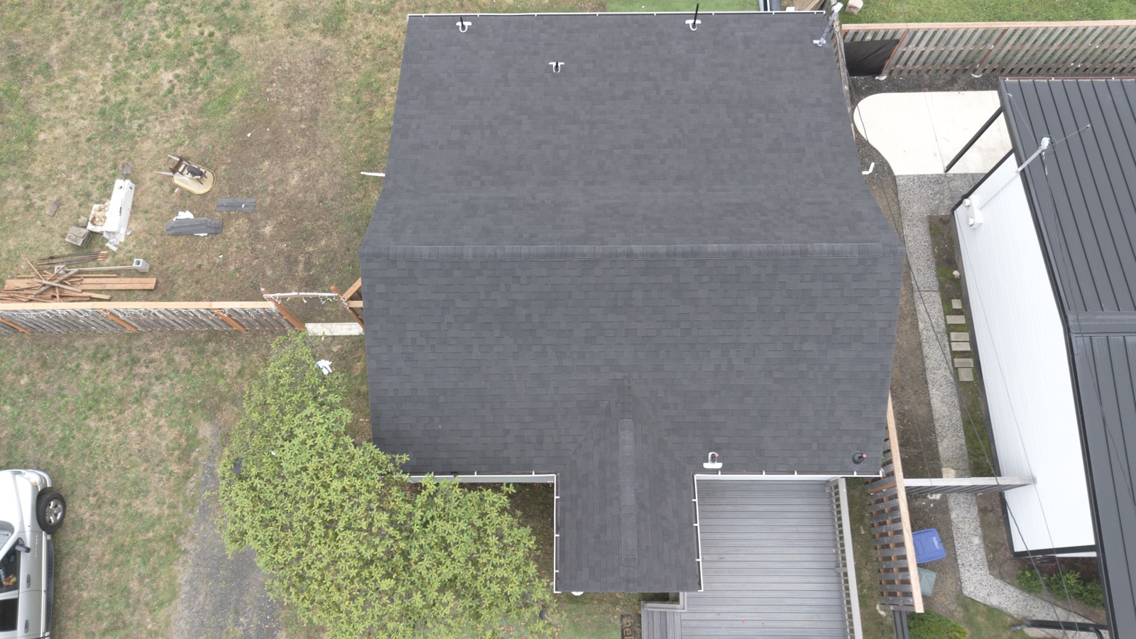Drone view straight down on the finished dark architectural shingle roof with new ridge cap and pipe boots